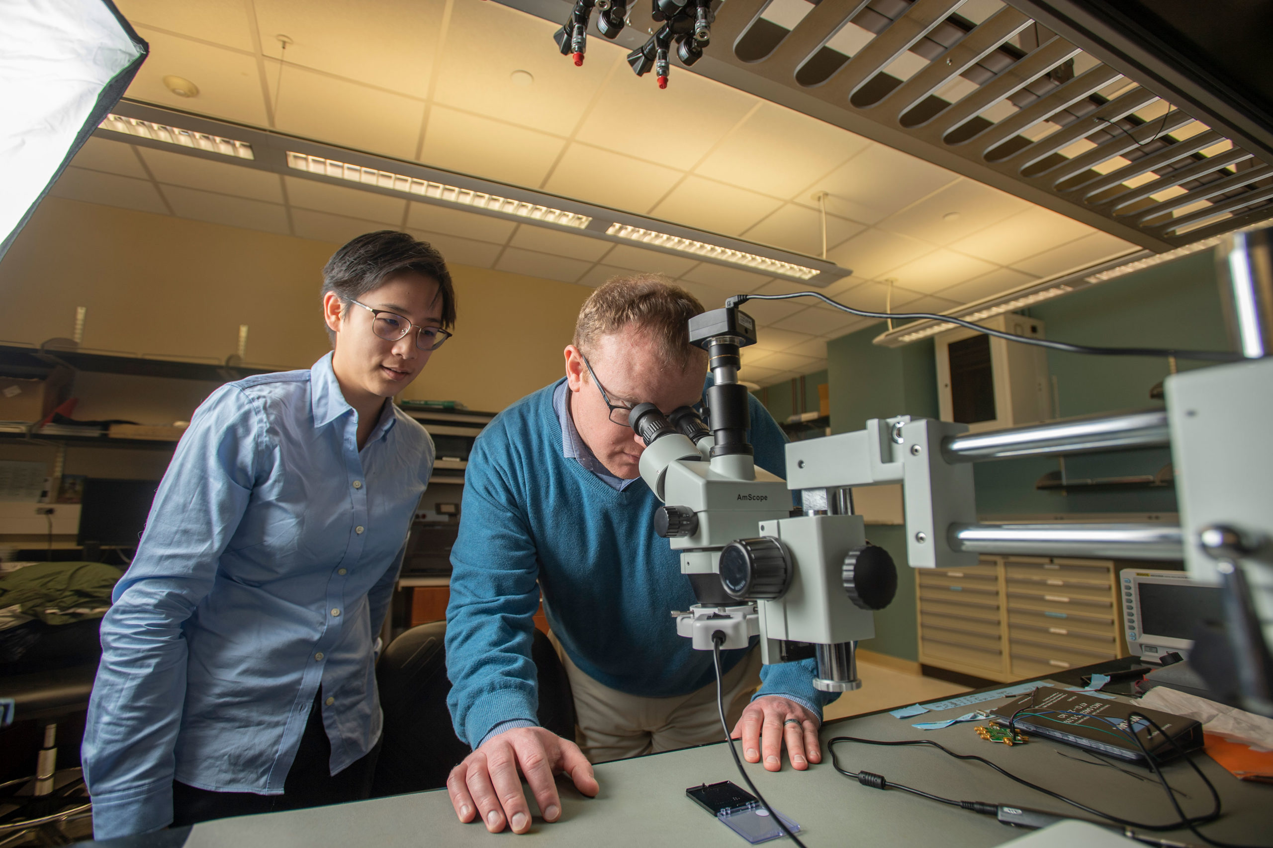 Thomas O’Sullivan and Alicia Wei using a microscope