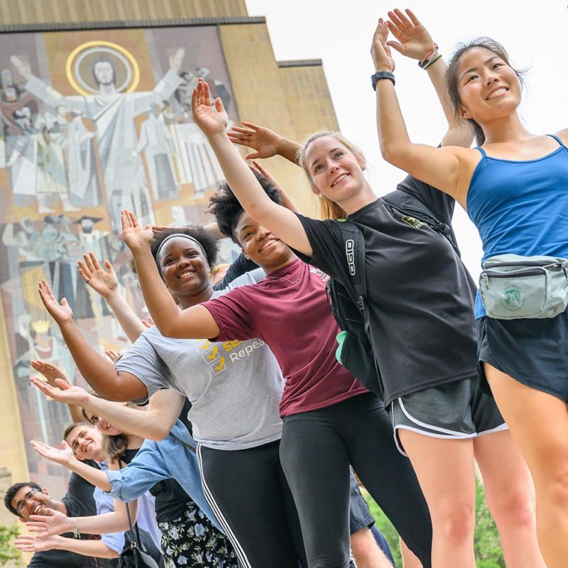 Graduate students participating in an orientation event in front of Hesburgh Library