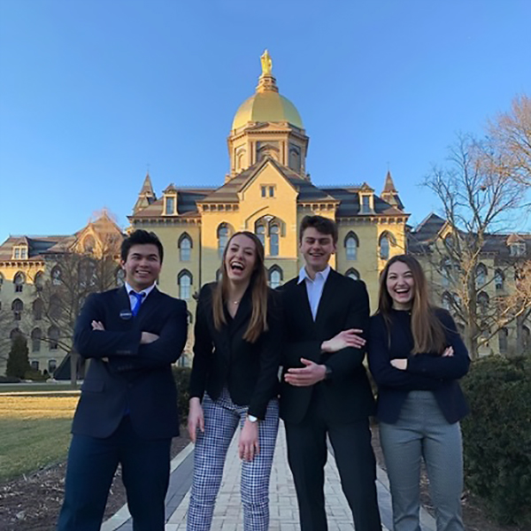 Notre Dame students standing together with Golden Dome in background