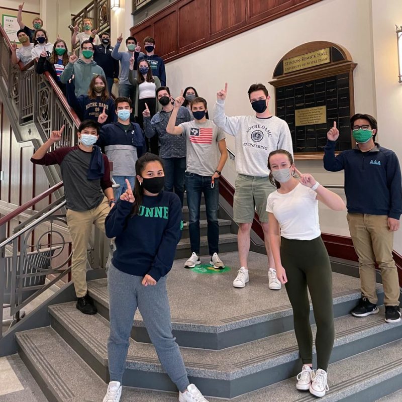 ASCE students holding up 1 finger on the steps in Stinson-Remick Atrium