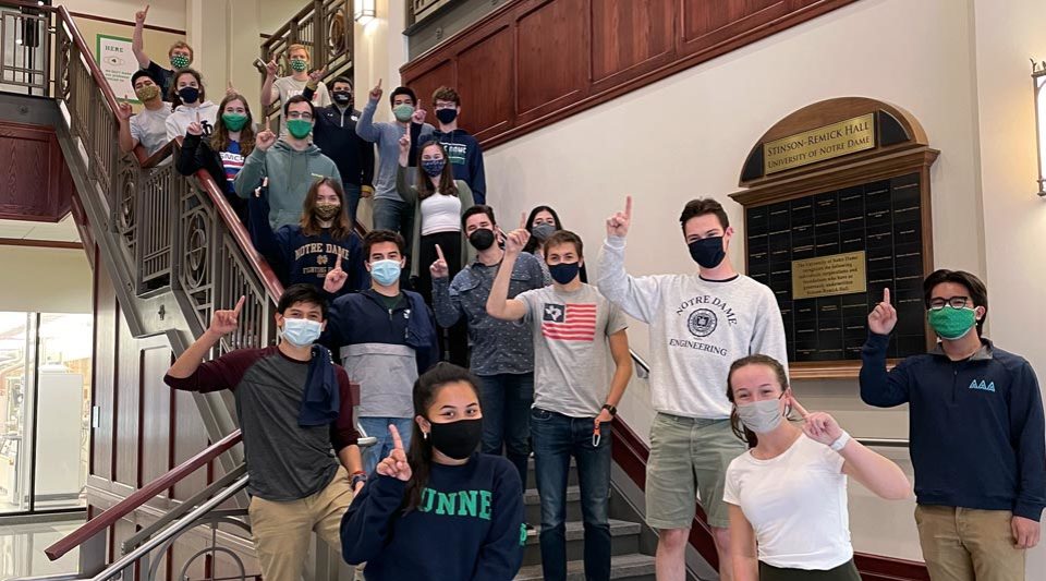 ASCE students holding up 1 finger on the steps in Stinson-Remick Atrium