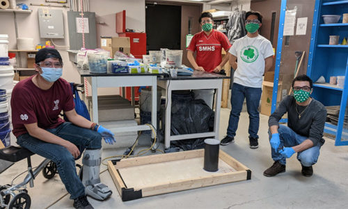 Concrete Cornhole Competition participants with cornhole board