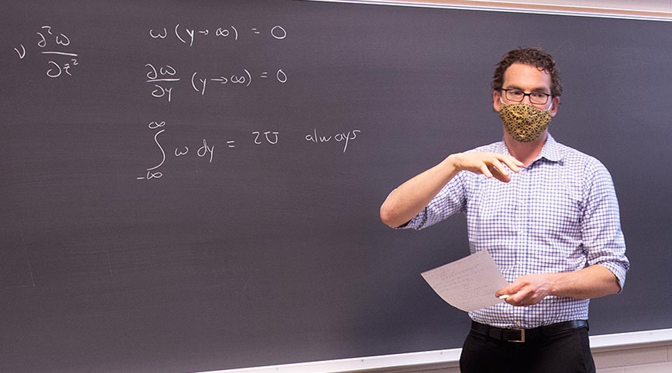 David Richter in front of chalkboard in classroom