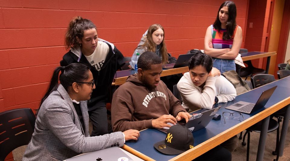 Prof. Kumar meeting with a group of 5 students in the classroom