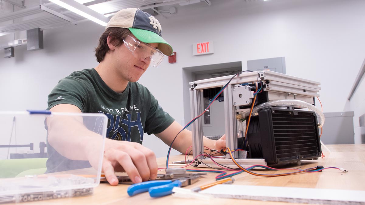 Male student assembling an electronic device in the Engineering Innovation Hub