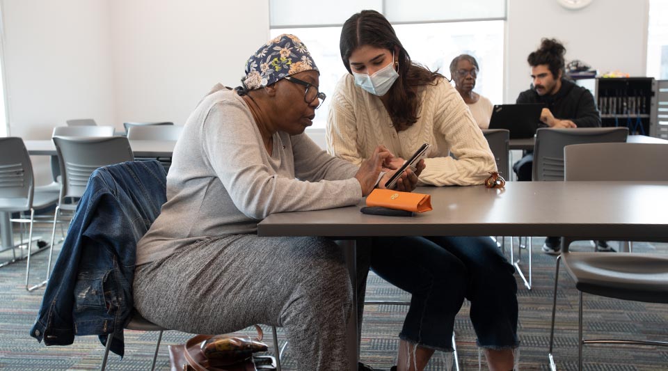 Students from Professor Kumar’s class helping older community members with their devices